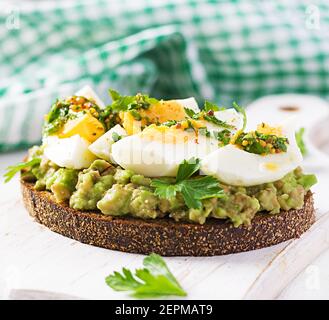 Vegetarian breakfast. Sandwich with avocado puree and boiled eggs.  Healthy breakfast or lunch. Stock Photo