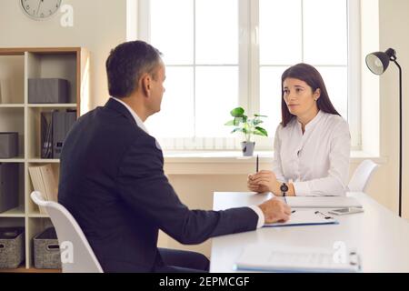 Two business people having business meeting in office, sitting at desk and talking Stock Photo