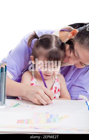Portrait of woman and little asian girl drawing, painting and smiling together, mother teach her daughter to draw with colour pencil , isolated on whi Stock Photo