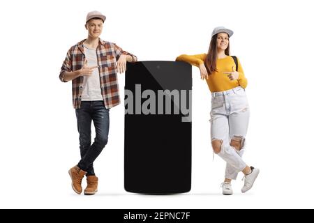 Teenage male and female with a big smartphone pointing at the screen isolated on white background Stock Photo