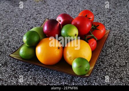 Oranges, lime, nectarines and other fruit on a platter Stock Photo