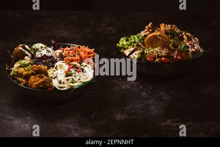 Appetizing organic vegetarian dishes with assorted vegetables on rustic dark table Stock Photo