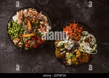 Appetizing organic vegetarian dishes with assorted vegetables on rustic dark table Stock Photo