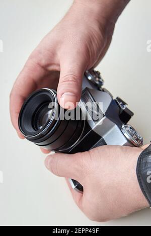 Retro camera in the hands of a man on a white background. Stock Photo