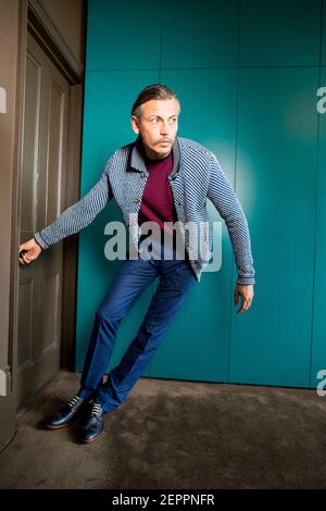 Male model fashion shoot in hotel suite with vintage telephone Stock Photo