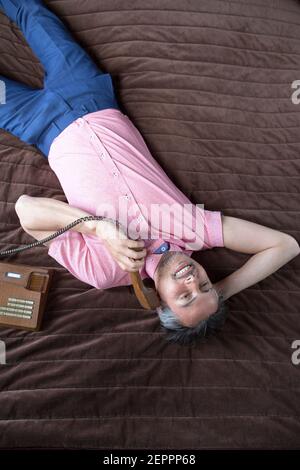 Male model fashion shoot in hotel suite with vintage telephone Stock Photo