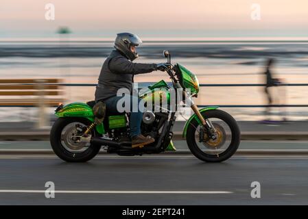 Custom motorcycle riding along Western Esplanade in Southend on Sea, Essex, UK, at dusk. S&S Super engine motorbike. Evening ride on seafront Stock Photo