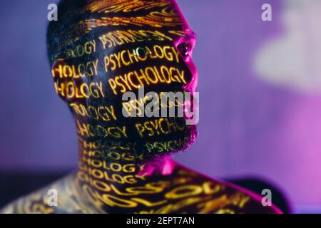 Young adult man with words Psychology on his face in the dark Stock Photo