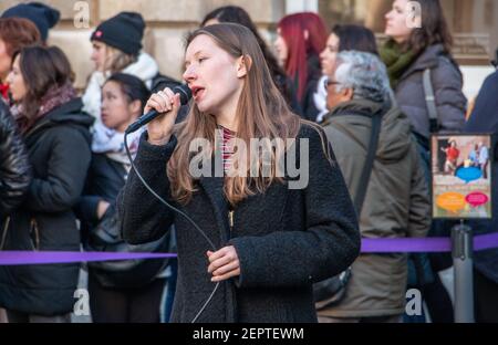 Female singer busking in front of the queue to the Roman Baths, Bath Abbey Church Yard, England, UK Stock Photo