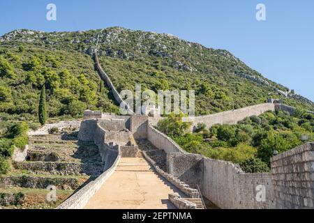 Narrow stone passage stairs on Wall of Ston aong hills in Croatia summer sunny morning Stock Photo