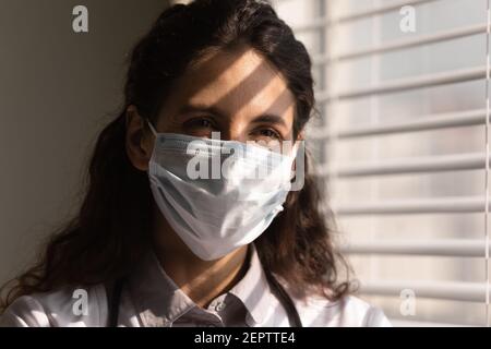 Head shot smiling female doctor wearing protective face mask Stock Photo