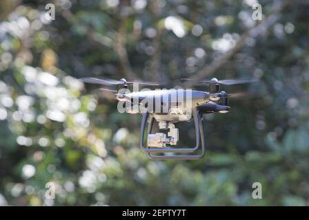 Mavic drone operating  at low level in a tropical rainforest Stock Photo