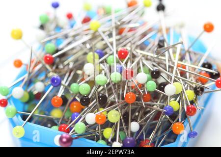 Multicolored dressmaker's needle push pins  box on white background Stock Photo