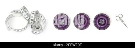 Sewing accessories cut and isolated on a large white background, with a tape measure, three purple buttons and a pair of scissors Stock Photo