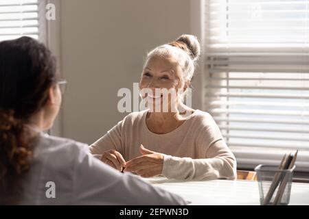 Close up smiling mature woman and doctor discussing treatment Stock Photo