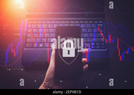 Hand hold phone with Virtual hologram padlock on laptop notebook background, data protection and insurance. The concept of business security, informat Stock Photo