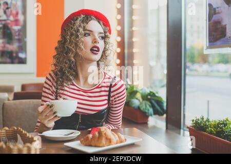 Young nice woman drinking coffee in cafeteria Stock Photo