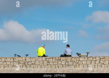 Marazion, Cornwall, UK. 28th February 2021. UK Weather. Cyclists taking a socially distanced breather on the sea front at Marazion today. Credit Simon Maycock / Alamy Live News. Stock Photo