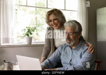 Happy mature couple studying internet application on laptop Stock Photo