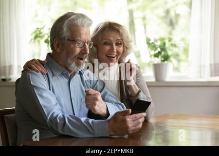 Surprised excited OAP family couple getting amazing good news Stock Photo