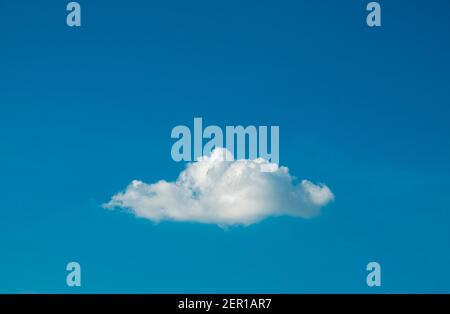 Cute white fluffy single cloud on clear blue sky background. Stock Photo