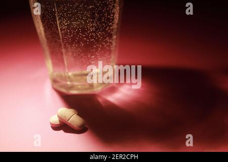 pills floating in water glass Stock Photo