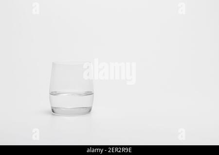 The half full glass of pure water isolated on a white background. A ...