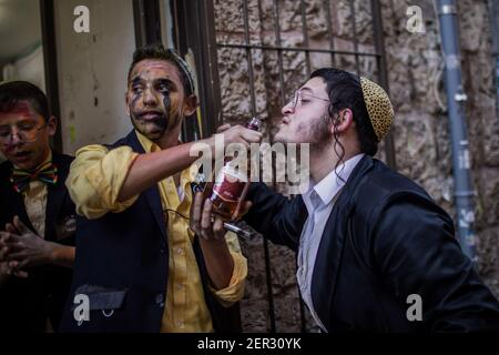 Jerusalem, Israel. 28th Feb, 2021. Ultra orthodox Jewish men take part in the celebrations of the Jewish holiday of Purim at Jerusalem's Mea She'arim neighbourhood. Purim, also called the Festival of Lots, is a carnival-like Jewish holiday that commemorates the saving of the Jewish people from a plot to massacre all the Jews in the ancient Persian Empire, as recounted in the Book of Esther. Credit: Ilia Yefimovich/dpa/Alamy Live News Stock Photo
