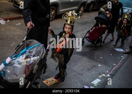 Jerusalem, Israel. 28th Feb, 2021. An Ultra orthodox Jewish boy dressed in costume, takes part in the celebrations of the Jewish holiday of Purim at Jerusalem's Mea She'arim neighbourhood. Purim, also called the Festival of Lots, is a carnival-like Jewish holiday that commemorates the saving of the Jewish people from a plot to massacre all the Jews in the ancient Persian Empire, as recounted in the Book of Esther. Credit: Ilia Yefimovich/dpa/Alamy Live News Stock Photo