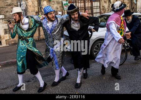 Jerusalem, Israel. 28th Feb, 2021. Ultra Orthodox Jewish men dressed in costumes, take part in the celebrations of the Jewish holiday of Purim at Jerusalem's Mea She'arim neighbourhood. Purim, also called the Festival of Lots, is a carnival-like Jewish holiday that commemorates the saving of the Jewish people from a plot to massacre all the Jews in the ancient Persian Empire, as recounted in the Book of Esther. Credit: Ilia Yefimovich/dpa/Alamy Live News Stock Photo