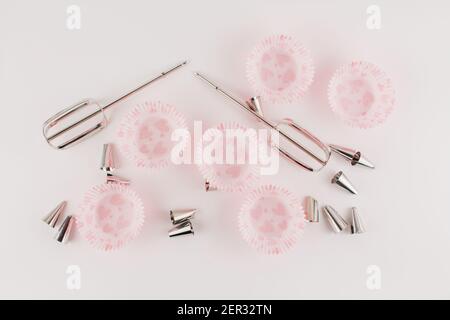 a mixer whisks and muffin molds on white baking plate Stock Photo