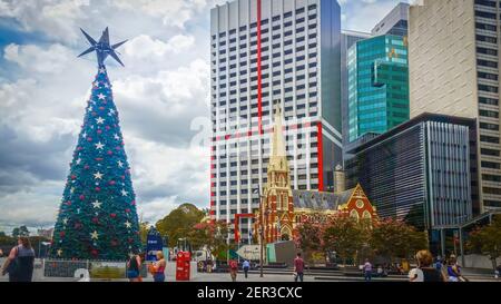 12-22-2014 Brisbane Australia - Solar Christmas tree and cute chapel with skyscrapers in background in the Central Business District Stock Photo
