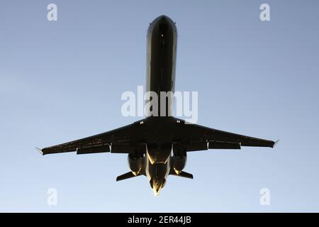 twin-engine jet on approach against blue sky Stock Photo