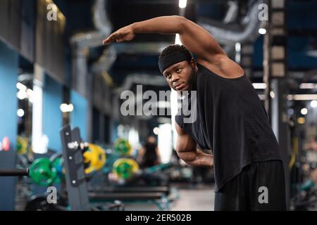African american bearded sportsman stretching his muscles before workout Stock Photo