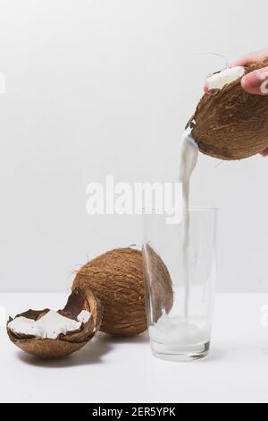 Glass bottle of milk or yogurt with coconuts on white background Stock Photo