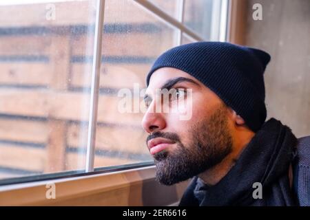 Arabic muslim man looking from window feeling sad Stock Photo