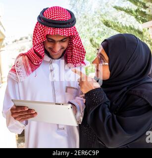 Muslim couple using tablet and discussing business Stock Photo