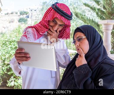 Muslim couple using tablet and discussing business Stock Photo
