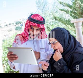Muslim couple using tablet and discussing business Stock Photo