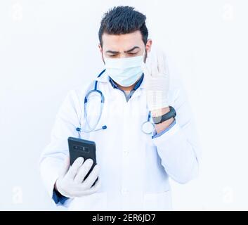 Arabic doctor using his smart phone to discuss medical stuff online Stock Photo