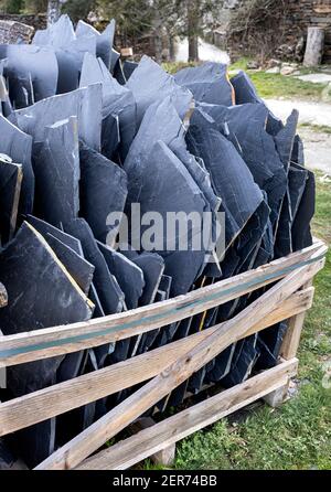 slate sheets on a pallet, building material ready to make a house with natural materials, black architecture, vertical Stock Photo