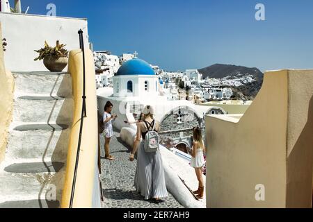 Santorini, Greece - September 11, 2017: Teenager girls or tourists traveling together taking pictures in the streets of famous greek island, Summer va Stock Photo