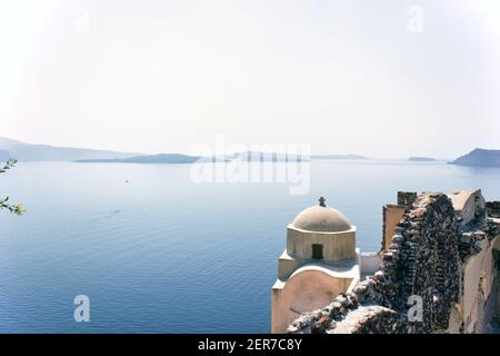 Santorini, Greece - September 11, 2017: Wide angle view of typical Church dome in Firostefani village and sea view with mountains in oia region agains Stock Photo