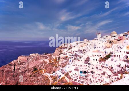 Santorini, Greece - September 11, 2017: Wide angle panoramic view of Oia Santorini white buildings on the hillside facing north against the blue sky. Stock Photo