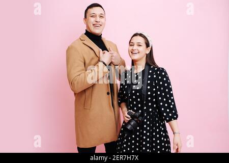 Woman photographer and a man in a coat posing and smiling  Stock Photo