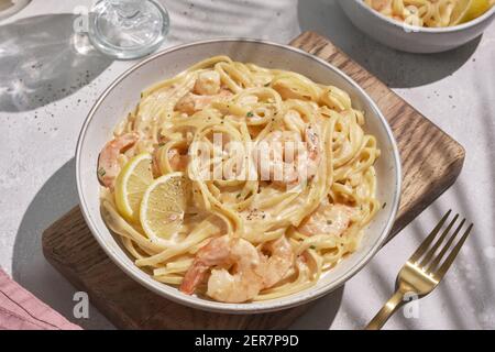Italian pasta fettuccine in a creamy sauce with shrimp and tomato Stock Photo