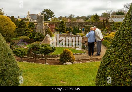 Isle of Wight, UK 04-25-2010 Elderly caucasian couple is visiting the famous Godshill model village. This miniature town has scaled models of historic Stock Photo