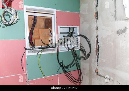 Construction site of a family house. Water pipes made of polypropylene in the wall, plumbing in the house. Distribution of electricity in the house. Stock Photo
