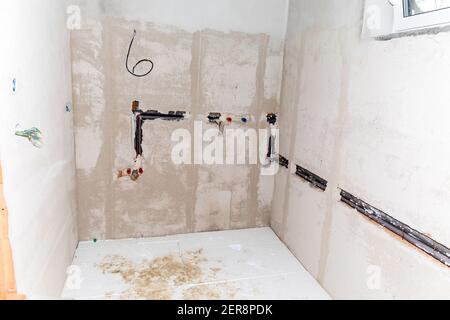 Construction site of a family house. Water pipes made of polypropylene in the wall, plumbing in the house. Distribution of electricity in the house. Stock Photo