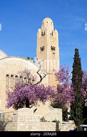 historical „Jerusalem International YMCA“ hotel building with it’s landmark viewing tower and blooming Almond trees in spring, Israel Stock Photo